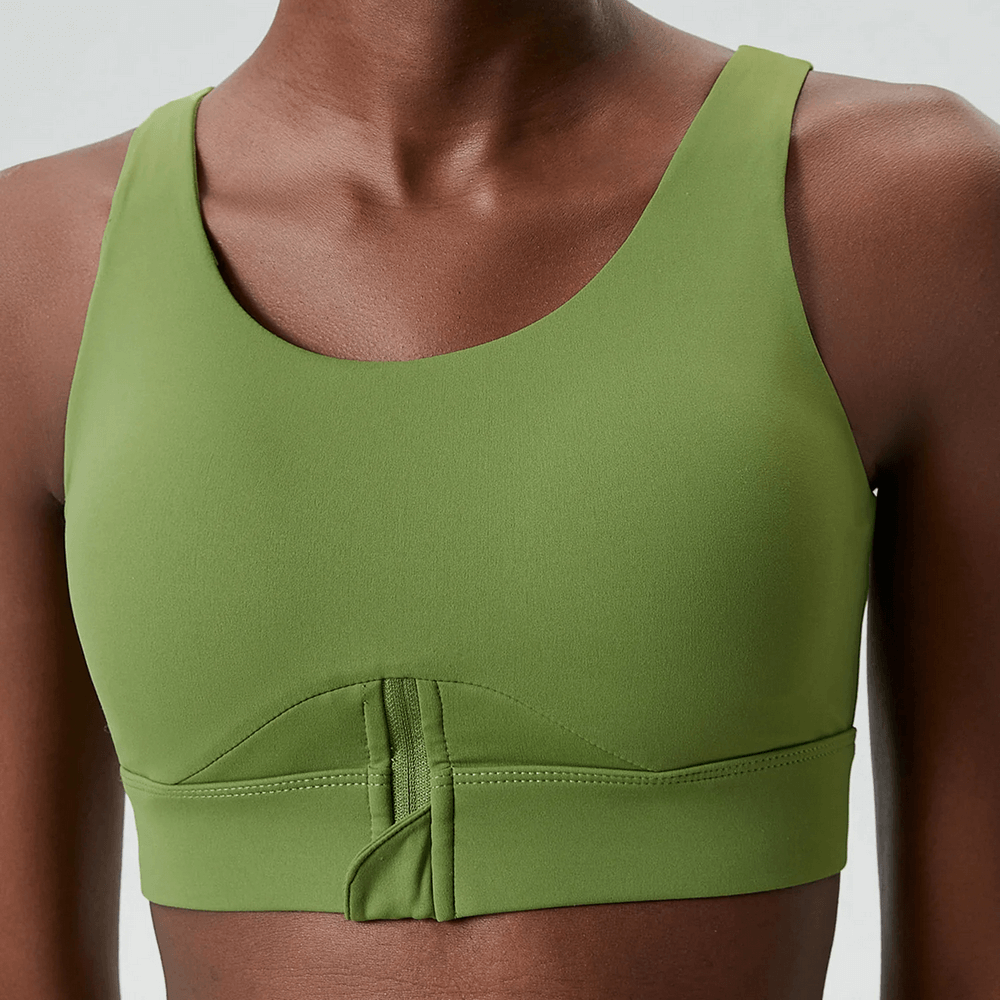 Green yoga fitness bra with half-zipper, offers breathability and flexibility, ideal for high-impact workouts. Nylon-Lycra blend, anti-friction.